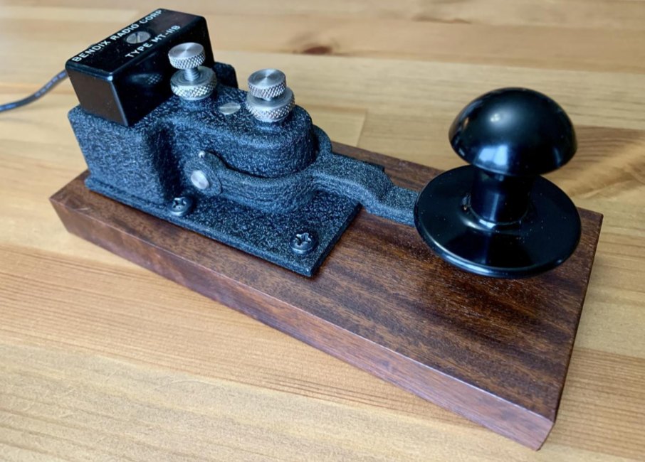 Black crackle-finish Bendix Radio flameproof straight key on a walnut base